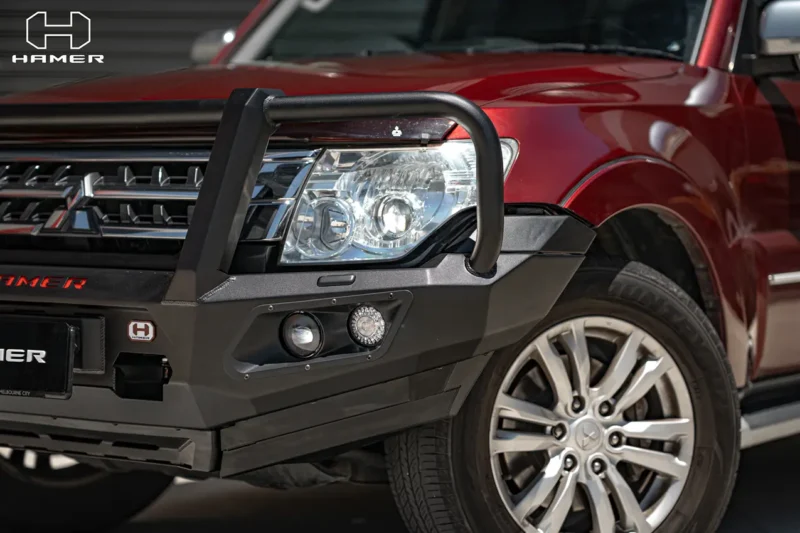 Close-up of a Hamer nudge bar with round driving lights fitted to a red Mitsubishi Pajero